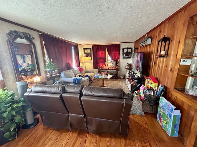 living room featuring hardwood / wood-style floors, a textured ceiling, and ornamental molding