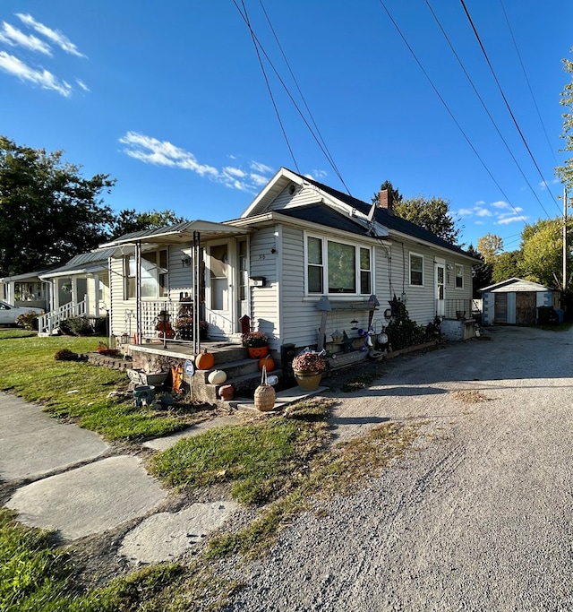 view of front of house with a porch and an outbuilding