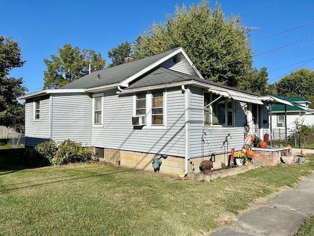 view of side of home with cooling unit and a lawn