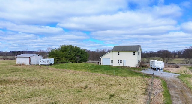 view of yard with an outdoor structure and dirt driveway