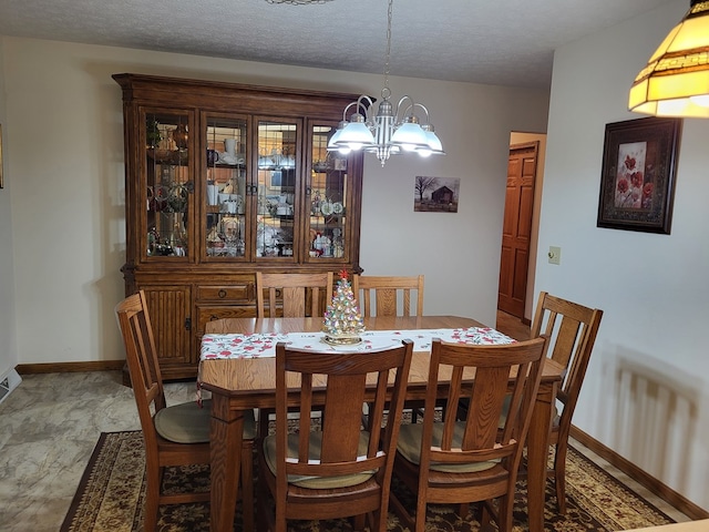 dining area featuring a textured ceiling and an inviting chandelier