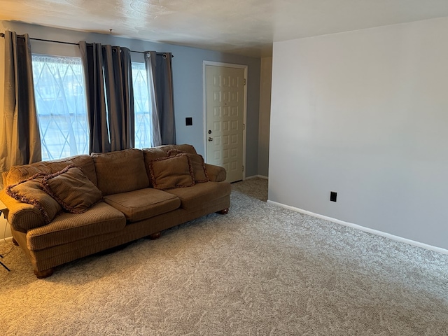 carpeted living room featuring baseboards