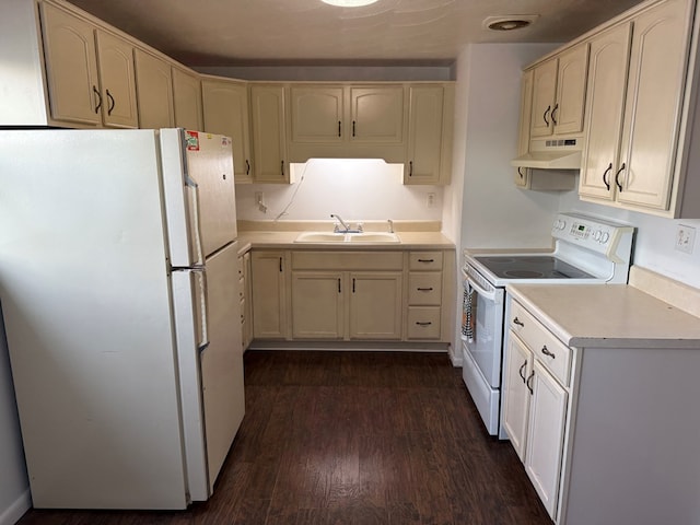 kitchen featuring white appliances, a sink, light countertops, dark wood-type flooring, and under cabinet range hood