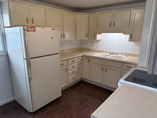 kitchen with a sink, cream cabinets, white appliances, light countertops, and dark wood-style flooring