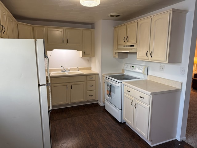 kitchen featuring white appliances, a sink, light countertops, dark wood-type flooring, and under cabinet range hood