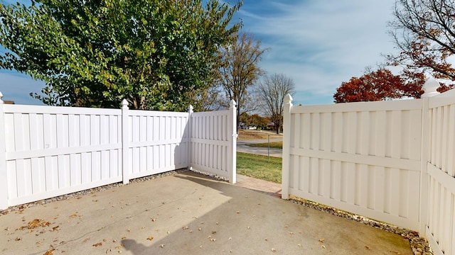 view of gate with a patio