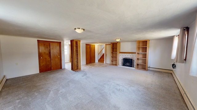 unfurnished living room featuring baseboard heating, light colored carpet, and a textured ceiling