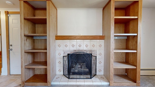 unfurnished living room with baseboard heating, built in shelves, crown molding, and a fireplace