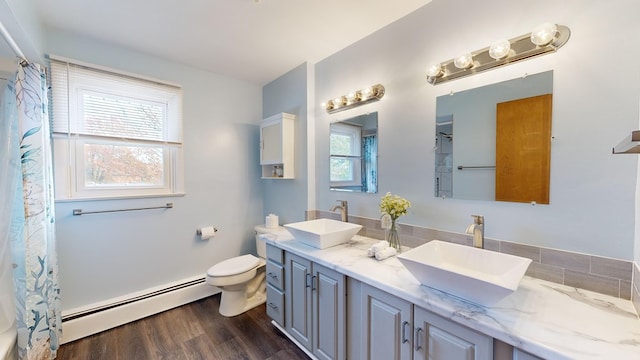 bathroom with baseboard heating, vanity, wood-type flooring, and toilet