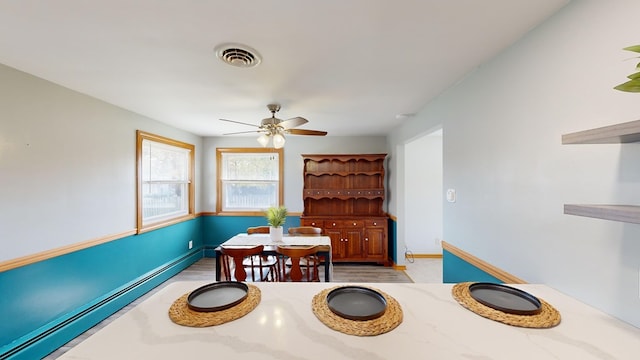 dining area with ceiling fan and a baseboard heating unit