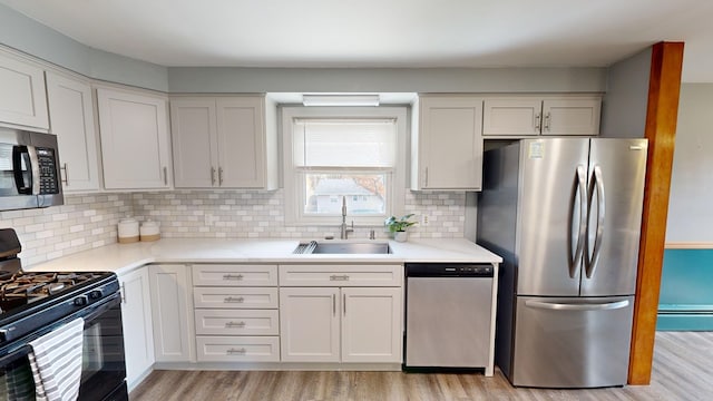 kitchen with white cabinets, appliances with stainless steel finishes, tasteful backsplash, and sink