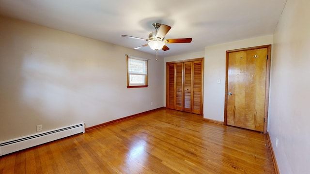 unfurnished bedroom with ceiling fan, a closet, light wood-type flooring, and a baseboard heating unit