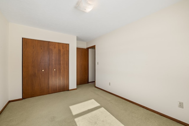 unfurnished bedroom featuring light colored carpet and a closet