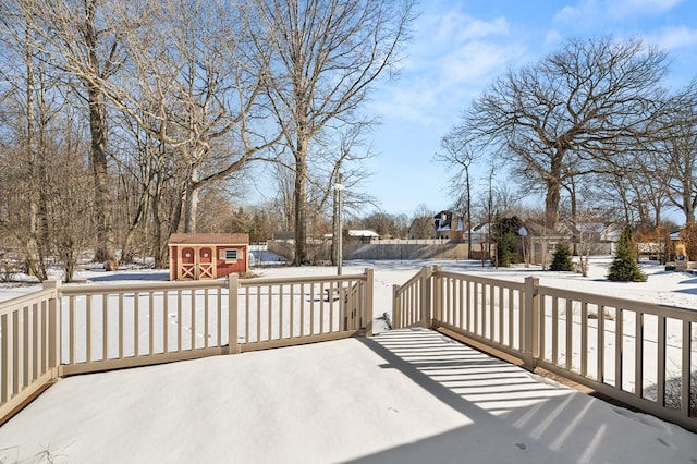 snow covered deck featuring a storage shed