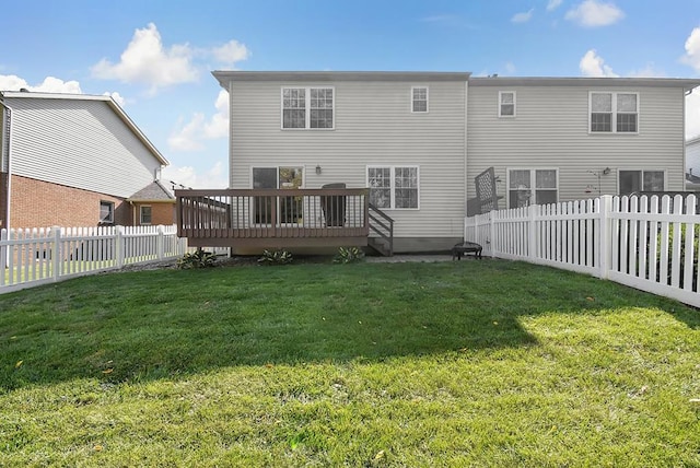 rear view of house with a lawn and a wooden deck