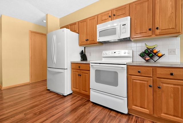 kitchen with tasteful backsplash, hardwood / wood-style floors, a textured ceiling, and white appliances