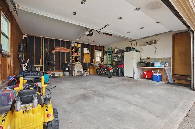 garage featuring freestanding refrigerator and a garage door opener