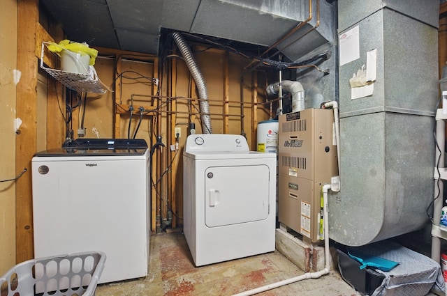 clothes washing area featuring water heater, laundry area, and washer and dryer