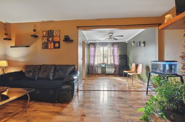 living room featuring crown molding, baseboards, ceiling fan, and hardwood / wood-style flooring
