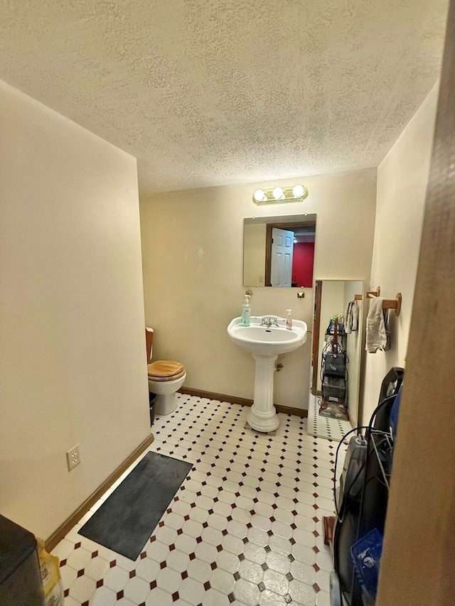 352 Valleybrook Cir, Howard, OH 43028 - bathroom with toilet, tile patterned floors, a textured ceiling, baseboards, and a sink
