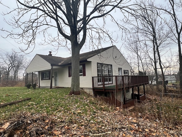 rear view of house with a lawn and a wooden deck