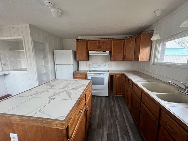 kitchen with sink, dark hardwood / wood-style floors, pendant lighting, a textured ceiling, and white appliances