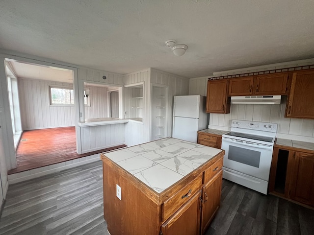 kitchen featuring a center island, dark wood-type flooring, tile countertops, a textured ceiling, and white appliances