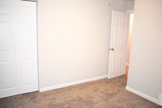 unfurnished bedroom with carpet floors and a closet