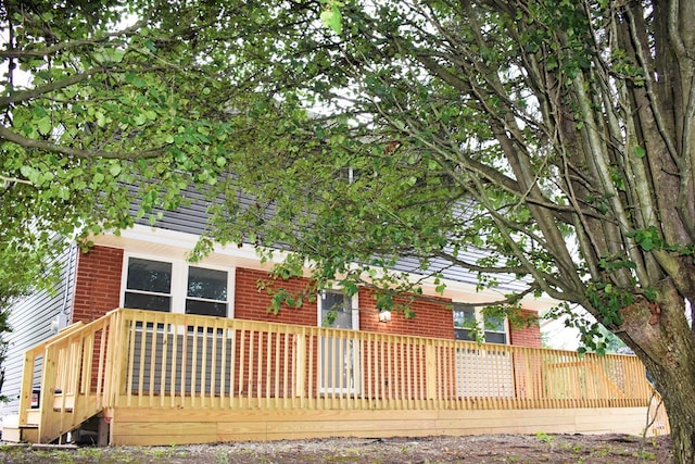 rear view of property featuring a wooden deck