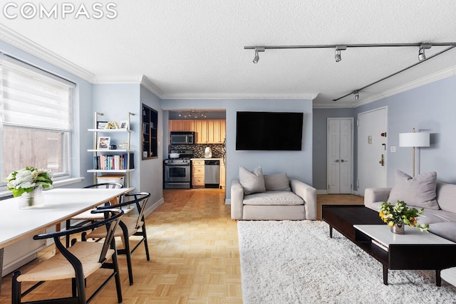 living room with light parquet floors, a textured ceiling, ornamental molding, and rail lighting