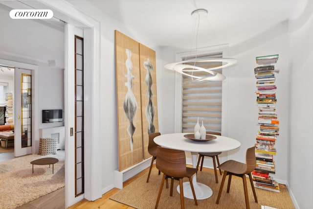 dining room with visible vents, light wood-style flooring, and baseboards