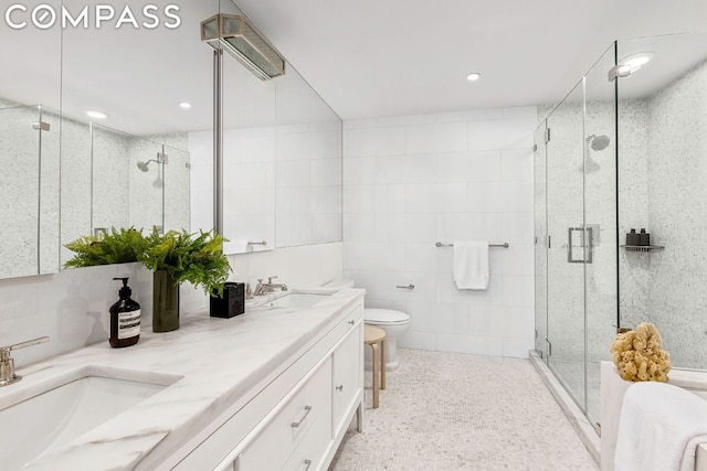 bathroom featuring tile walls, toilet, vanity, and an enclosed shower