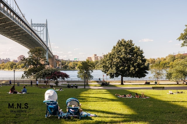 surrounding community featuring a lawn and a water view