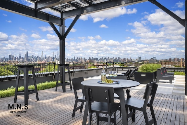 wooden terrace featuring a city view and outdoor dining area