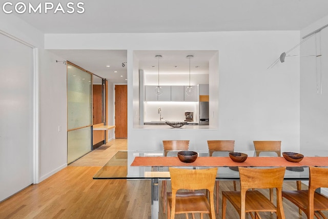 dining space featuring light hardwood / wood-style floors and sink