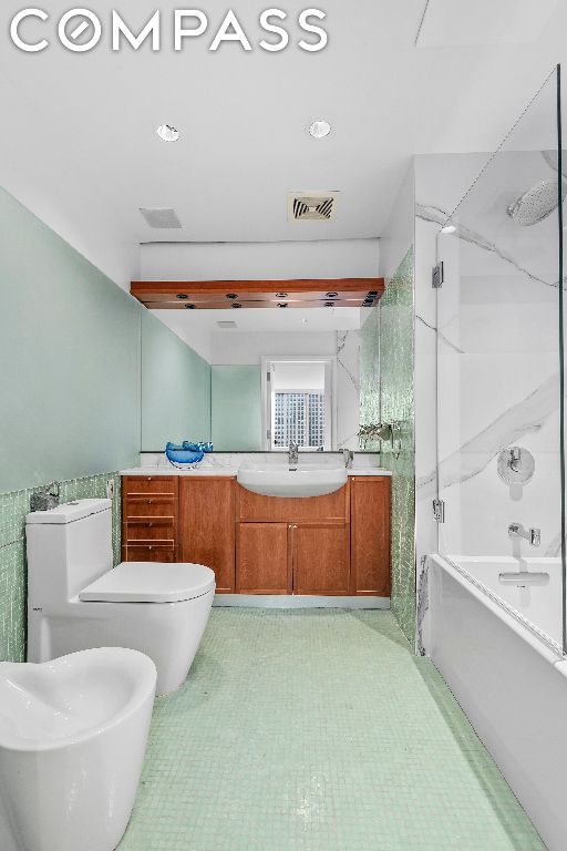 full bathroom with shower / bathtub combination, toilet, vanity, and a bidet