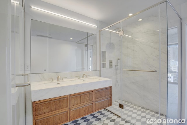 bathroom with recessed lighting, a marble finish shower, and double vanity