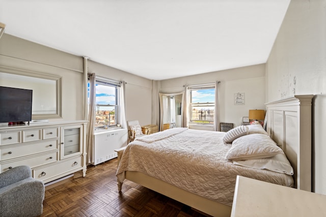 bedroom featuring multiple windows and radiator heating unit