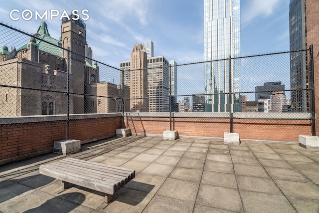 view of patio with a city view and fence