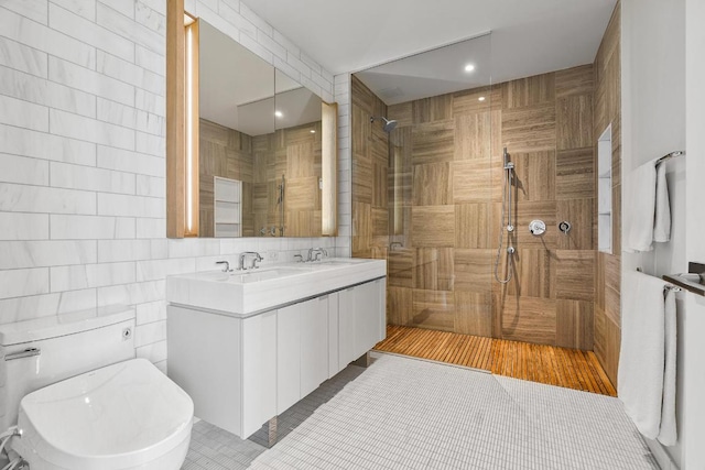 bathroom featuring a walk in shower, toilet, a sink, tile walls, and double vanity