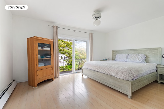 bedroom with a baseboard heating unit, light hardwood / wood-style flooring, and access to outside