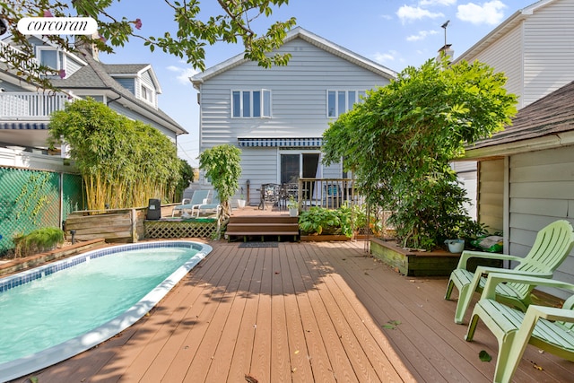 rear view of property featuring a swimming pool side deck