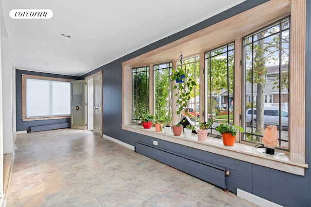 hallway featuring a baseboard heating unit and ornamental molding