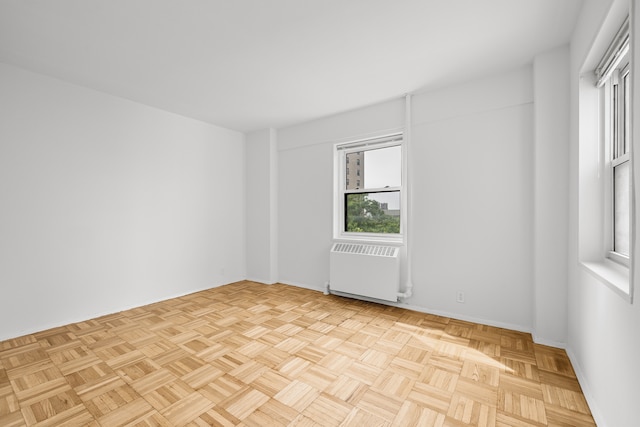 spare room featuring radiator and baseboards