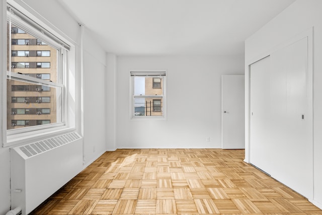 unfurnished room featuring radiator heating unit