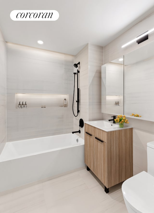 bathroom featuring shower / washtub combination, vanity, toilet, and tile walls