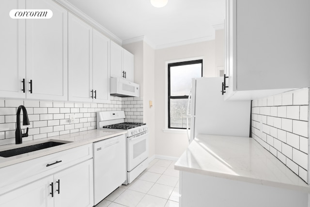 kitchen with sink, crown molding, white appliances, light stone countertops, and white cabinets