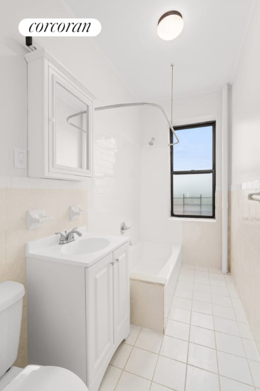 full bathroom featuring tile walls, vanity, tile patterned floors, and toilet