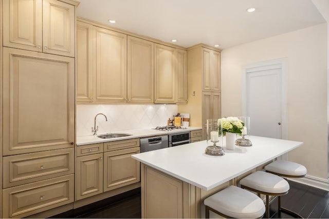 kitchen with a center island, dark hardwood / wood-style flooring, sink, backsplash, and a breakfast bar