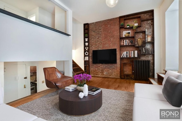 living room with built in shelves and hardwood / wood-style floors